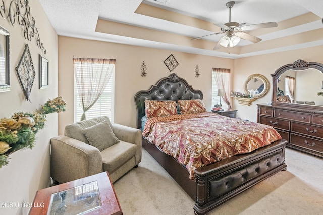8436 Ansley Park Ln, Southaven, MS 38672 - bedroom featuring a tray ceiling, multiple windows, light colored carpet, and ceiling fan