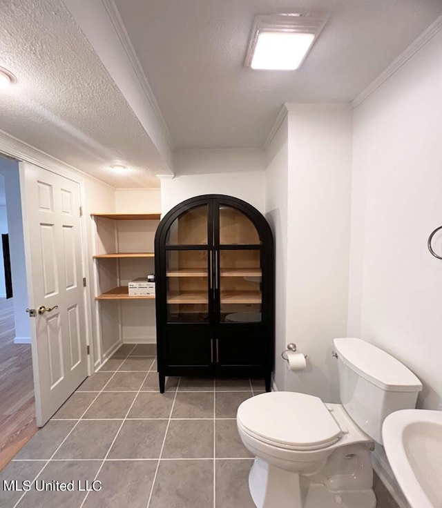 216 Buena Vista Dr, Long Beach, MS 39560 - bathroom with crown molding, toilet, tile patterned flooring, and a textured ceiling