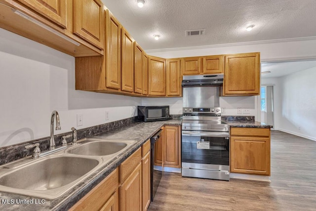 216 Buena Vista Dr, Long Beach, MS 39560 - kitchen with under cabinet range hood, black appliances, dark countertops, a sink, and visible vents