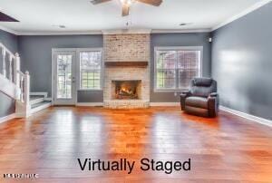 living room with wood finished floors, baseboards, ceiling fan, and crown molding