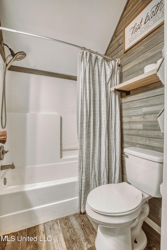 bathroom with wooden walls, shower / bath combo, lofted ceiling, toilet, and wood finished floors