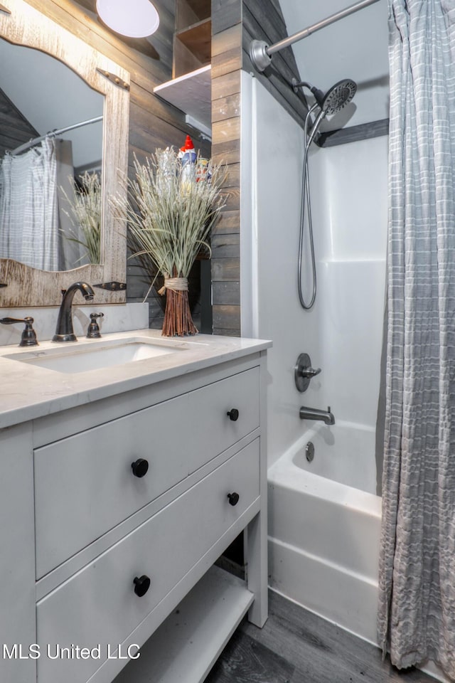 full bath featuring wood finished floors, vanity, and shower / tub combo with curtain