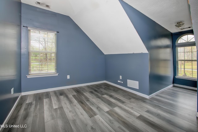 bonus room featuring vaulted ceiling, wood finished floors, and baseboards