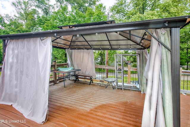 wooden deck with a gazebo and view of scattered trees