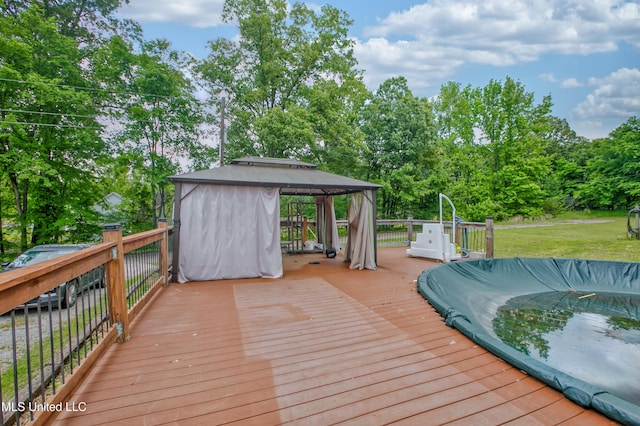 wooden terrace with a gazebo, a yard, and view of scattered trees