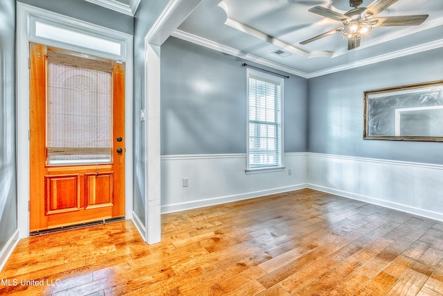 foyer featuring light wood finished floors, ceiling fan, crown molding, and a tray ceiling