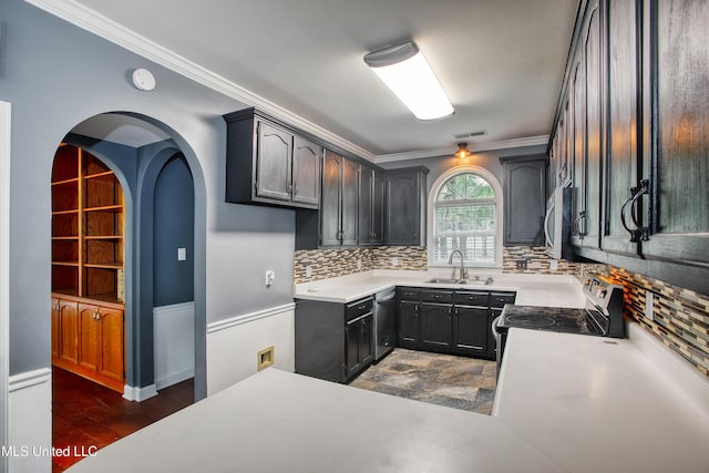 kitchen with a sink, appliances with stainless steel finishes, backsplash, ornamental molding, and light countertops