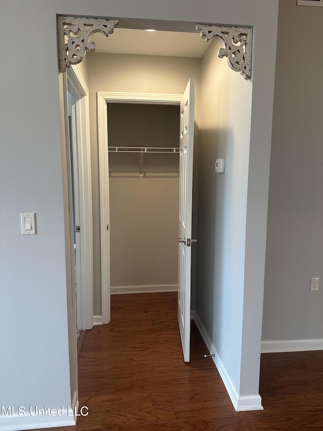 hallway featuring baseboards and wood finished floors