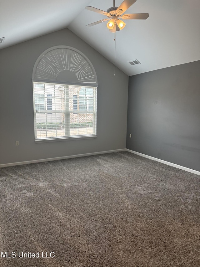 carpeted spare room with lofted ceiling, ceiling fan, visible vents, and baseboards