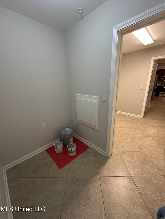 empty room featuring light tile patterned floors and baseboards