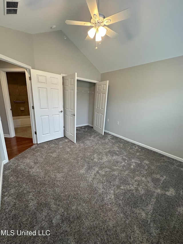 unfurnished bedroom with a closet, visible vents, vaulted ceiling, and carpet flooring