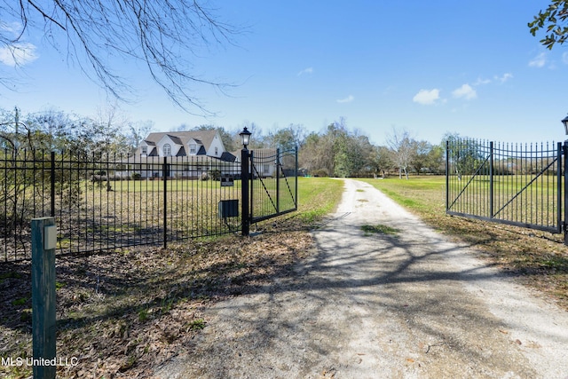 view of gate with a lawn and fence