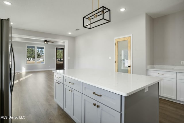 kitchen featuring open floor plan, stainless steel refrigerator with ice dispenser, dark wood finished floors, and a center island