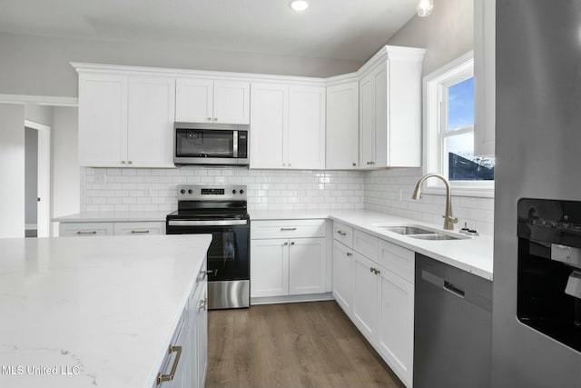 kitchen featuring stainless steel appliances, dark wood-style flooring, a sink, and white cabinetry