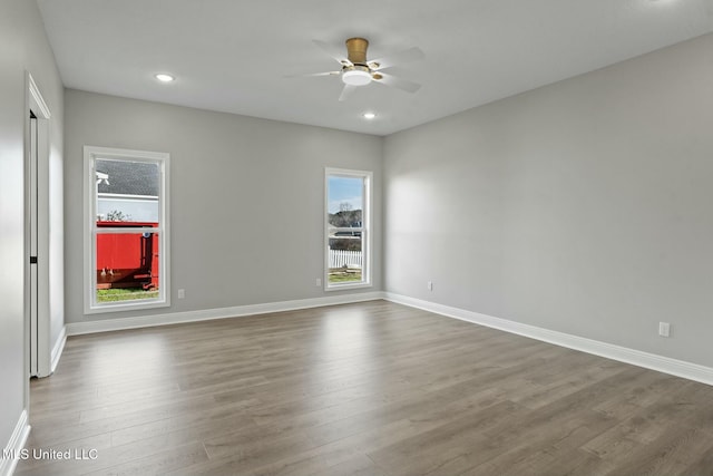 empty room featuring plenty of natural light, baseboards, and dark wood finished floors