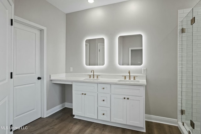 bathroom with a shower stall, a sink, and wood finished floors