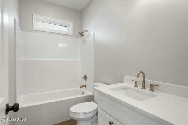 bathroom featuring tub / shower combination, vanity, and toilet