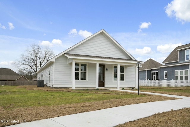 view of front facade featuring a porch, a front yard, central AC, and fence