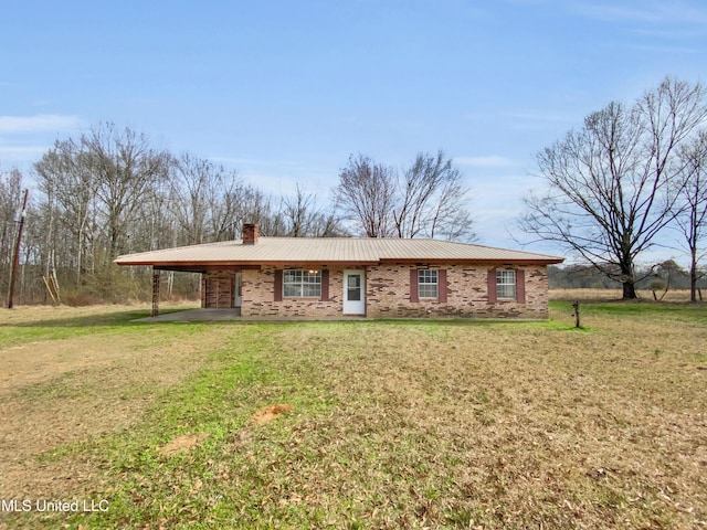 single story home with a chimney, a front lawn, a carport, and brick siding