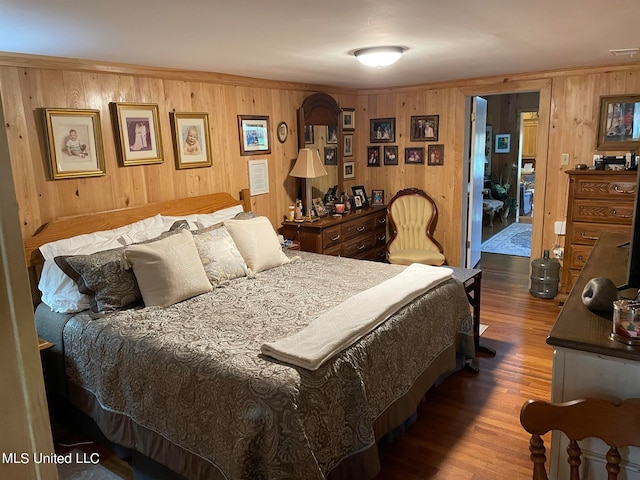 bedroom featuring wood walls and dark wood-type flooring