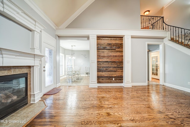 9480 Miranda Dr, Olive Branch, MS 38654 - unfurnished living room with wood finished floors, a chandelier, high vaulted ceiling, a tiled fireplace, and stairway