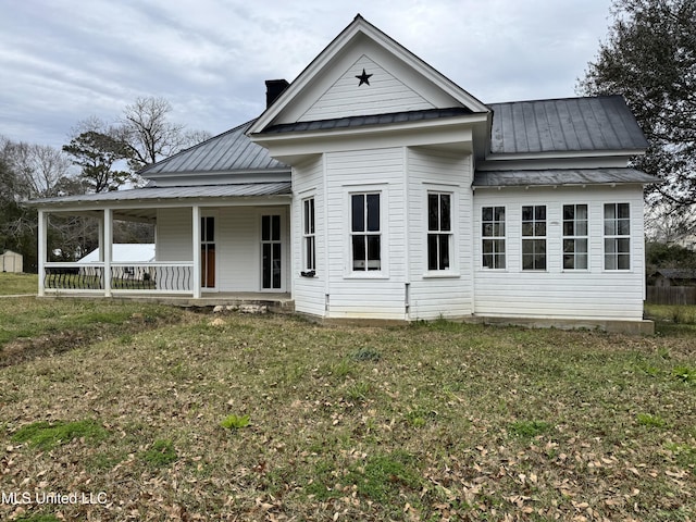 view of front of home with metal roof, a porch, a standing seam roof, and a front lawn