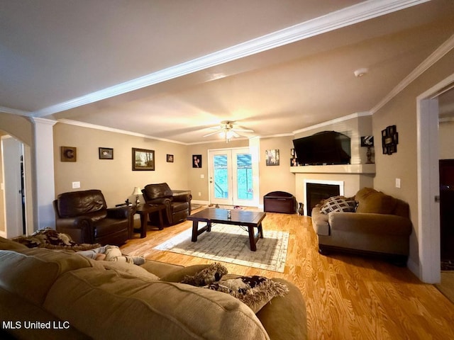 living room with light hardwood / wood-style flooring, ceiling fan, and ornamental molding