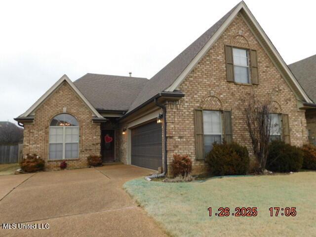 view of front of property with a garage and a front lawn