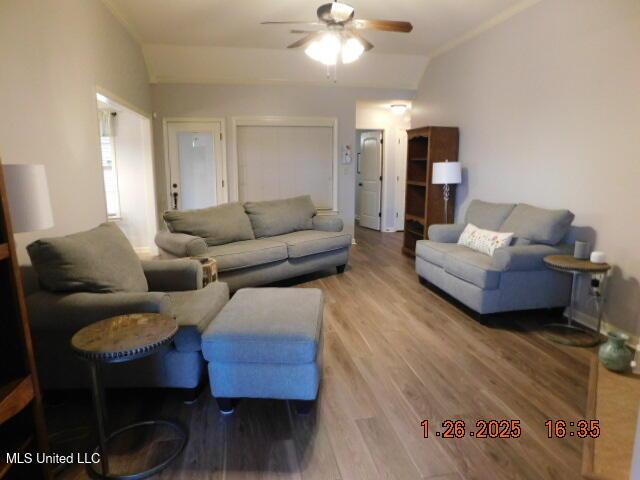 living room featuring ceiling fan, vaulted ceiling, and wood-type flooring