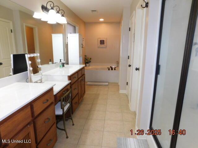 bathroom featuring vanity, a bath, and tile patterned flooring