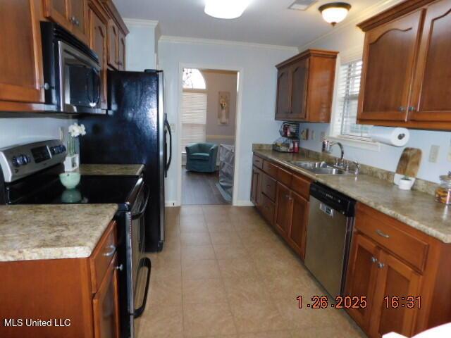 kitchen with sink, ornamental molding, and stainless steel appliances