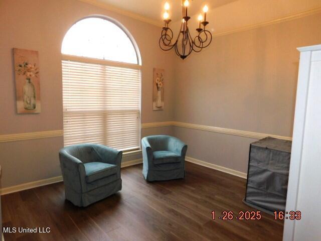 sitting room featuring an inviting chandelier, ornamental molding, and dark hardwood / wood-style floors