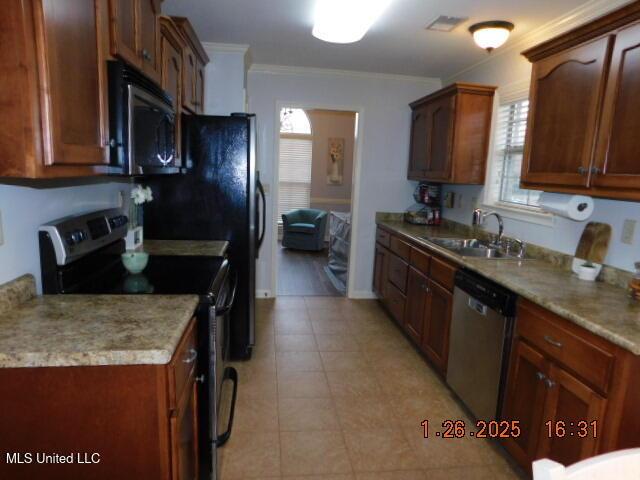 kitchen with ornamental molding, appliances with stainless steel finishes, sink, and plenty of natural light