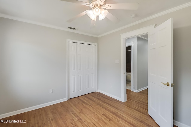 unfurnished bedroom featuring ornamental molding, a closet, light wood-type flooring, and ceiling fan