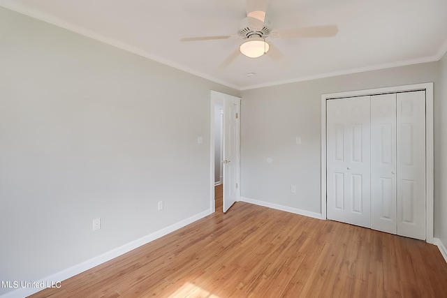 unfurnished bedroom featuring a closet, crown molding, light wood-type flooring, and ceiling fan