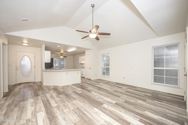 unfurnished living room featuring vaulted ceiling, ceiling fan, and light hardwood / wood-style floors