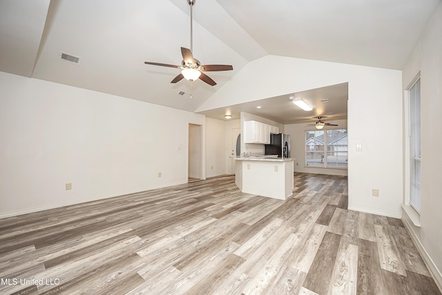 unfurnished living room featuring lofted ceiling, ceiling fan, and light hardwood / wood-style flooring