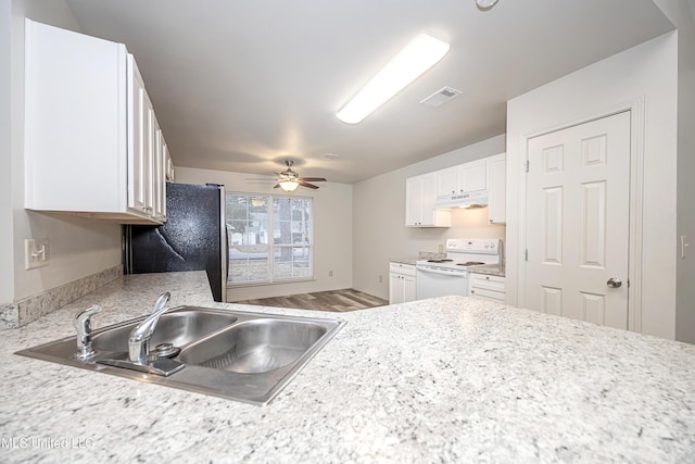 kitchen featuring sink, stainless steel refrigerator, white range with electric cooktop, hardwood / wood-style floors, and white cabinets