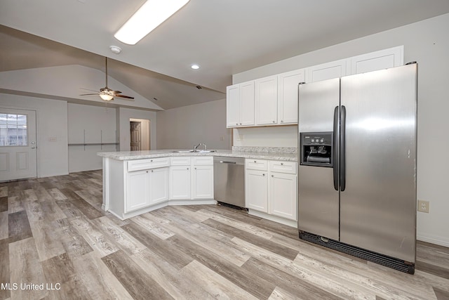 kitchen featuring sink, white cabinetry, vaulted ceiling, appliances with stainless steel finishes, and kitchen peninsula