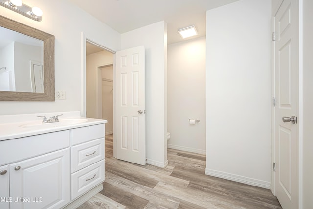 bathroom featuring vanity, hardwood / wood-style floors, and toilet