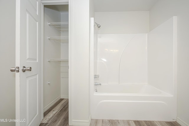 bathroom with hardwood / wood-style floors and tub / shower combination