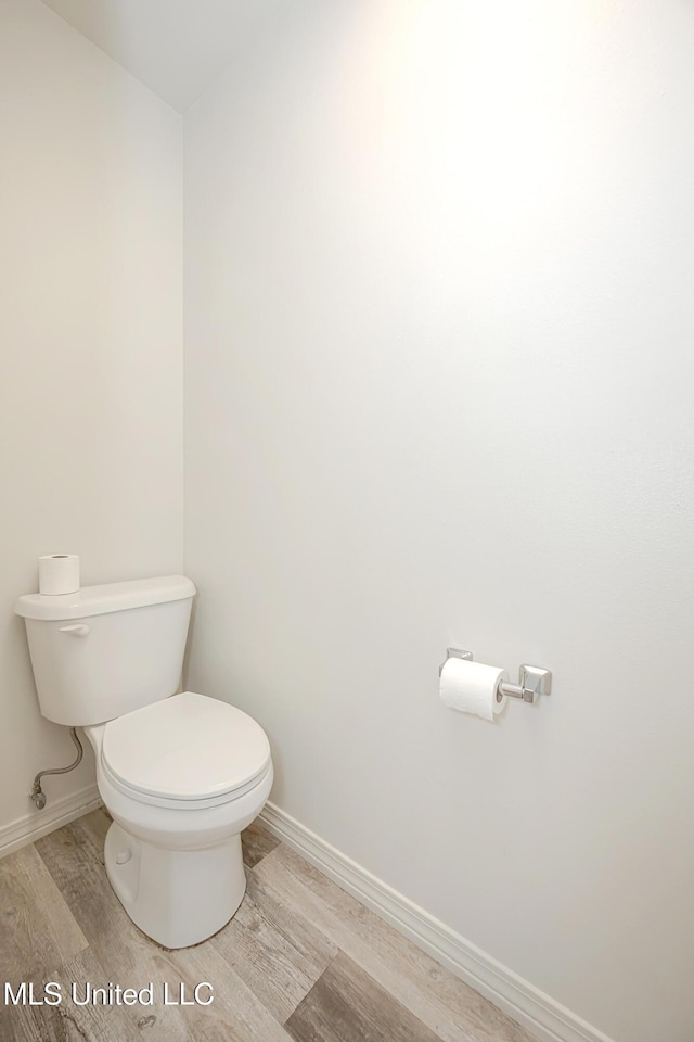 bathroom with hardwood / wood-style flooring and toilet