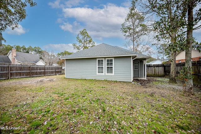 rear view of property with a lawn