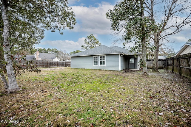 back of property featuring a lawn