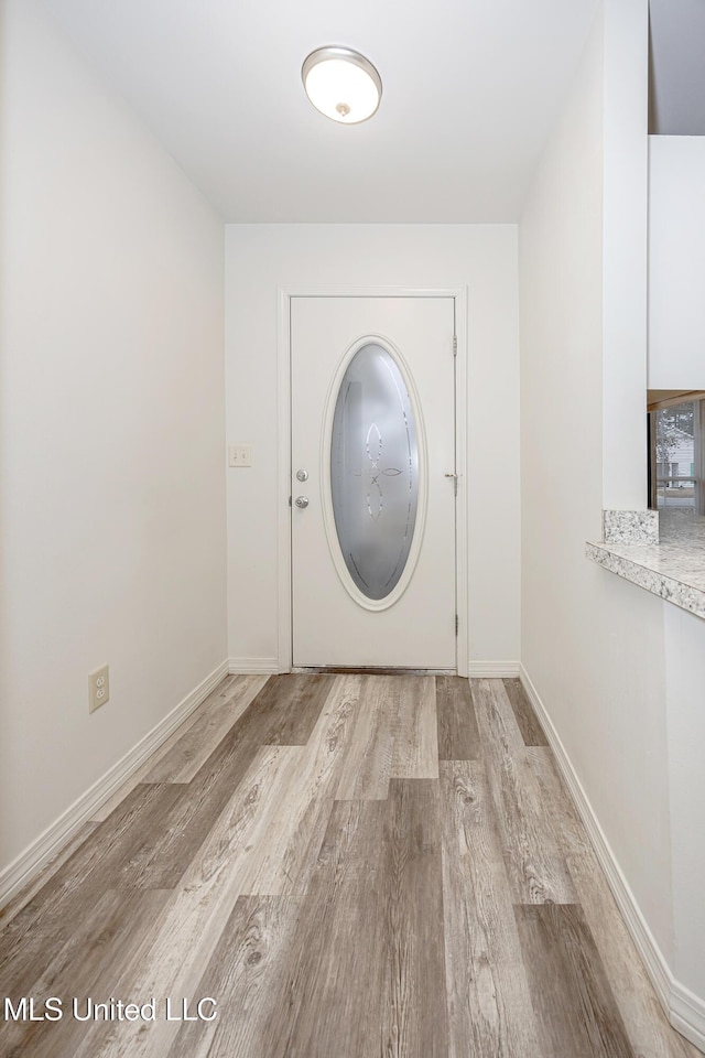 clothes washing area with light hardwood / wood-style floors