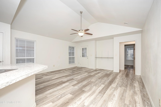 unfurnished living room with ceiling fan, vaulted ceiling, and light wood-type flooring