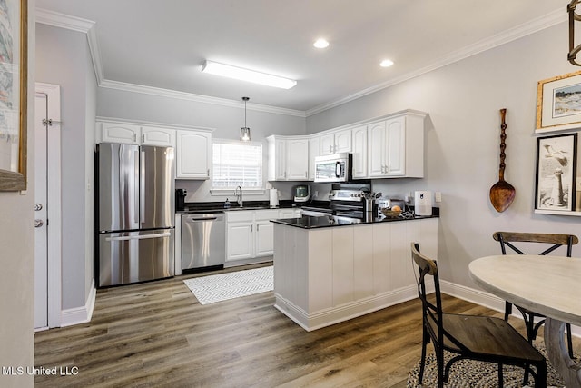 118 Armand Oaks, Ocean Springs, MS 39564 - kitchen with stainless steel appliances, dark countertops, white cabinetry, a peninsula, and dark wood-style floors