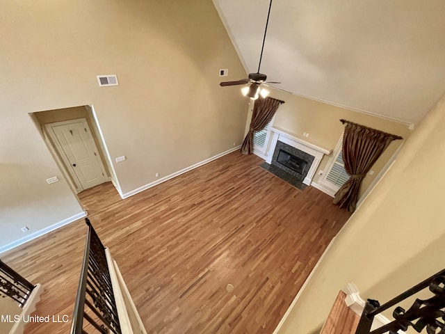 unfurnished living room with ceiling fan, high vaulted ceiling, and hardwood / wood-style floors