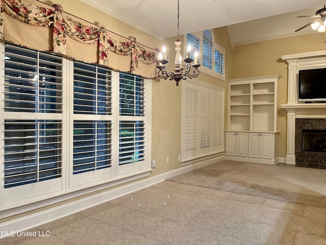 unfurnished dining area with ceiling fan with notable chandelier, ornamental molding, lofted ceiling, and a high end fireplace