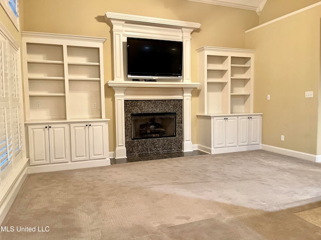 unfurnished living room with a premium fireplace, ornamental molding, and carpet